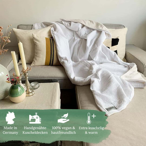 Kuschelige weiche warme Decke von Blanketino in weiß auf dem Sofa.